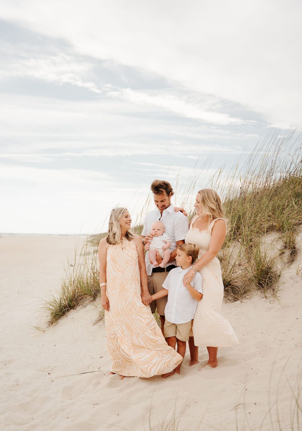 Three generations together on the dune in soft evening light