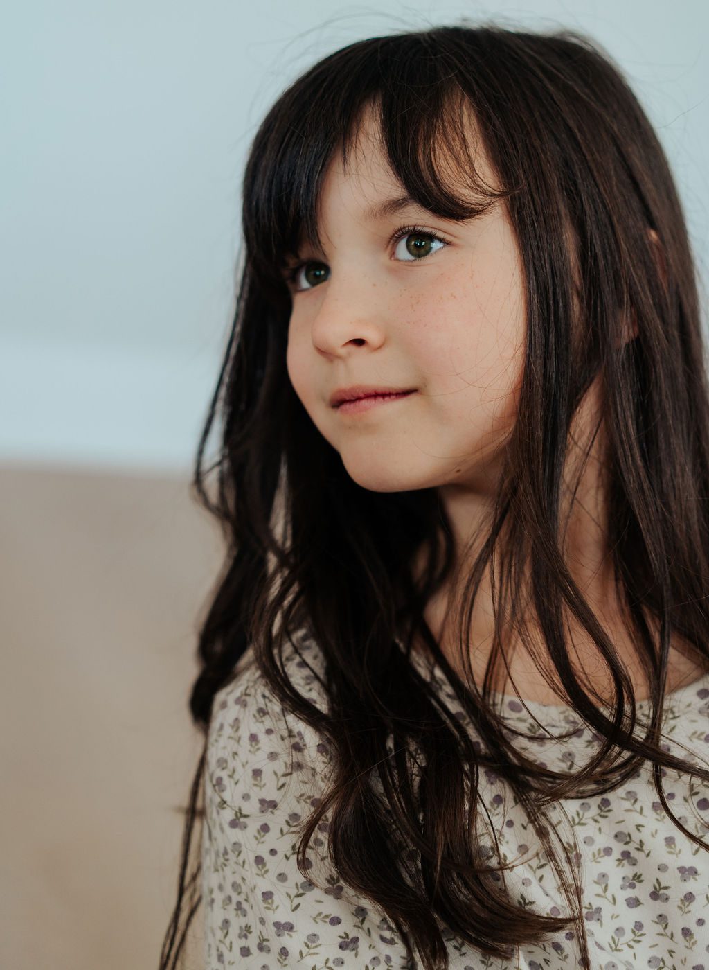 Portrait of a girl with dark hair and a soft floral dress