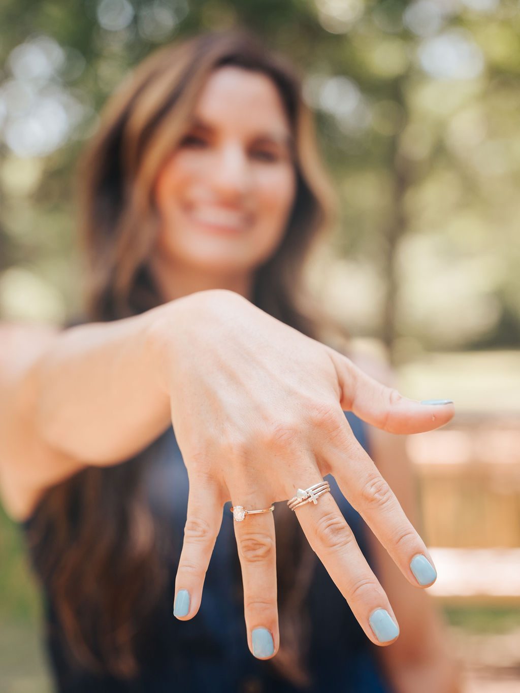 Close detail of a hand wearing delicate stacked rings
